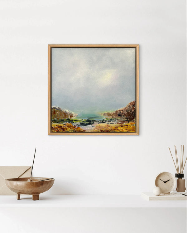 Framed landscape painting on a white wall with decorative items below.