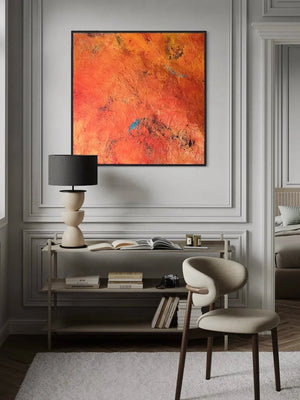 Modern interior with a desk, chair, and abstract orange painting on a gray wall.