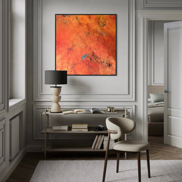 Modern interior with a desk, chair, and abstract orange painting on a gray wall.